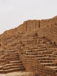 Low angle view of stone wall against sky