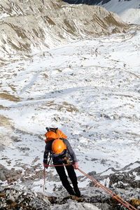 Hiker climbing snow covered mountain