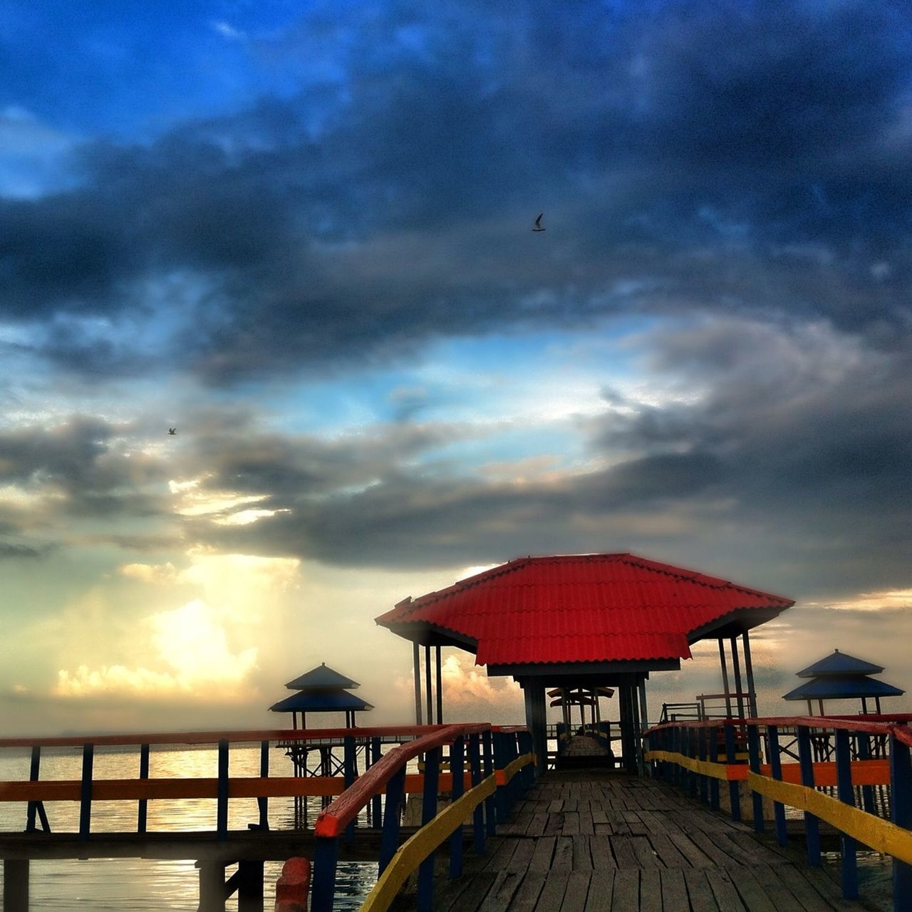 sky, cloud - sky, built structure, sea, architecture, railing, cloudy, pier, sunset, water, cloud, horizon over water, nature, scenics, tranquility, beauty in nature, beach, building exterior, the way forward, tranquil scene