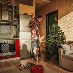 Portrait of smiling young woman holding christmas tree