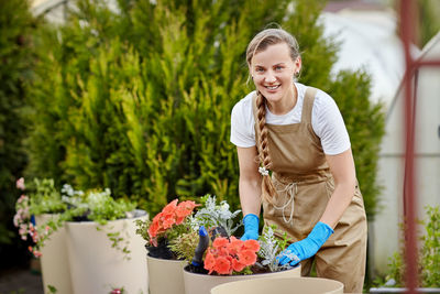 Portrait of a smiling young woman holding flowering plants