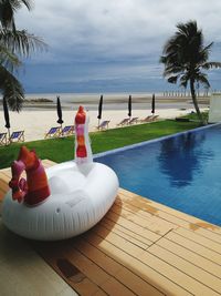 View of swimming pool by sea against sky