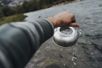 Midsection of person holding ice cream in water