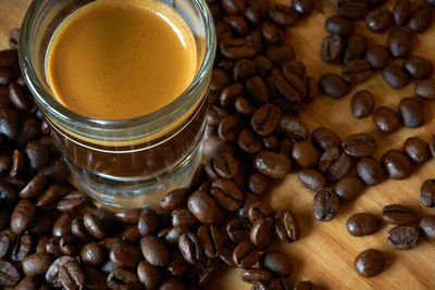 High angle view of coffee with roasted beans on table