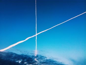 Low angle view of vapor trail against blue sky