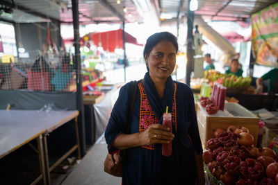 Portrait of smiling woman standing at market
