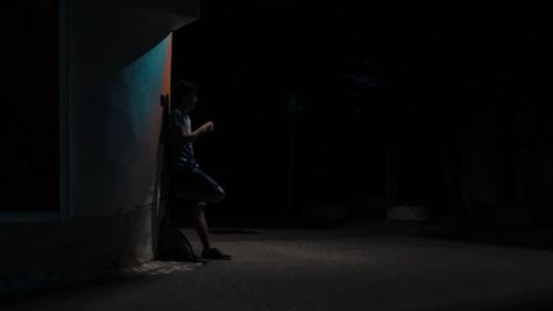 Side view of young woman standing in corridor