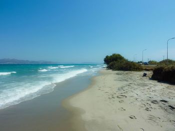 Scenic view of beach against clear blue sky