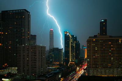 Panoramic view of illuminated buildings in city against sky at night