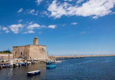 Boats in sea against buildings