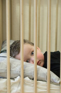 Portrait of boy resting on bed