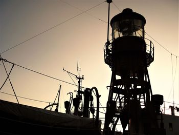 Low angle view of silhouette electricity pylon against sky