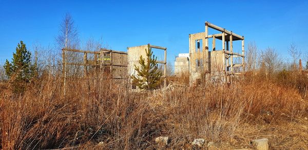 Built structure on field against clear blue sky