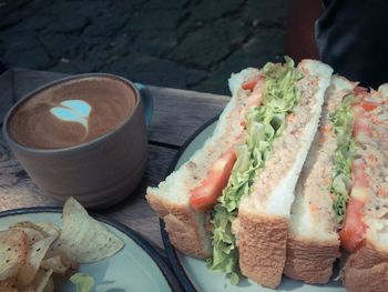High angle view of sandwiches by coffee cup on table