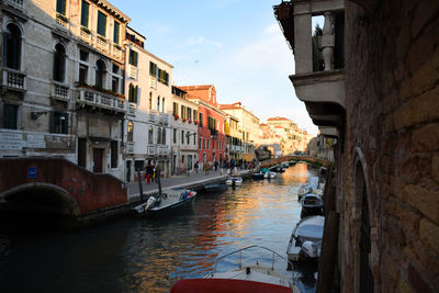 Canal amidst buildings in city against sky