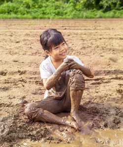 Portrait of little girl playing in mud