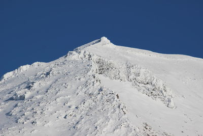 Scenic view of snowcapped mountains against clear blue sky