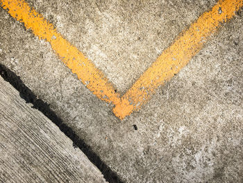 High angle view of yellow arrow symbol on road