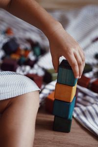 Low section of woman holding toy blocks