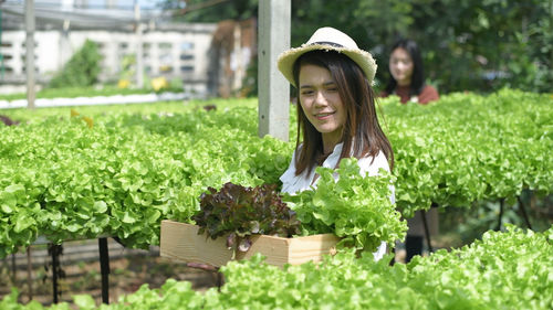 Portrait of smiling woman with green plants