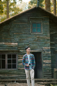 Man standing against old house