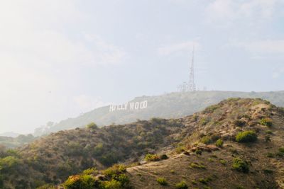 View of hollywood sign on mountain against cloudy sky