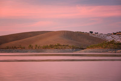 Desert like hill landscape with reflection on the water on a dam lake reservoir  in terena, portugal