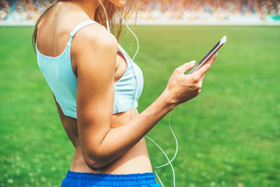 Midsection of woman using mobile phone outdoors