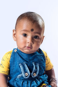 Close-up portrait of baby boy against white background