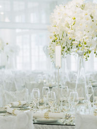 Bouquet with wineglasses arranged on table in hotel during wedding ceremony