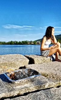 Rear view of woman sitting on beach