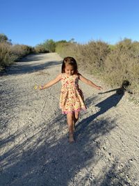 Full length of little girl walking along land playfully