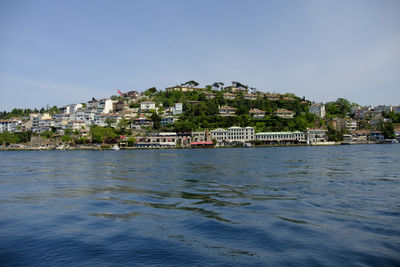 Buildings by sea against sky in town