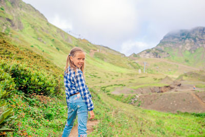 Rear view of woman standing on mountain