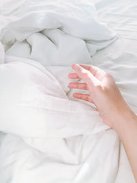 Midsection of woman lying on bed