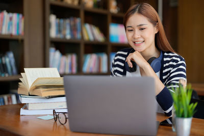 Portrait of woman using laptop at table