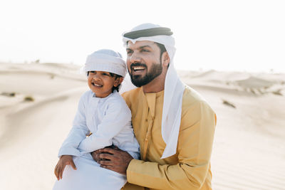 Happy young man standing on beach