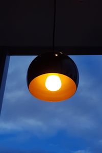 Low angle view of illuminated light bulb against sky