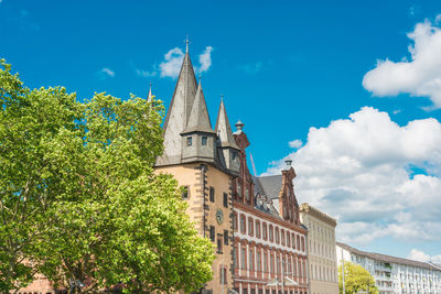 Buildings and trees in city against sky