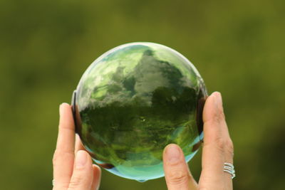 Close-up of hand holding crystal ball