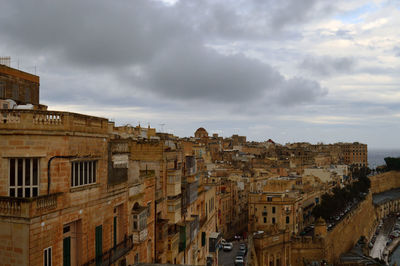 Low angle view of buildings against cloudy sky