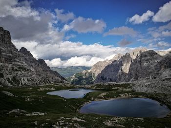 Scenic view of lake and mountains against cloudy sky