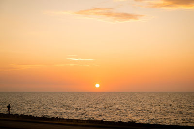 Scenic view of sea against orange sky