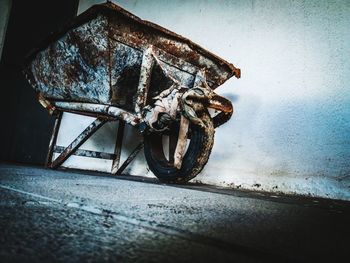 Close-up of rusty bicycle against wall