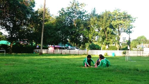 People relaxing on grassy field in park