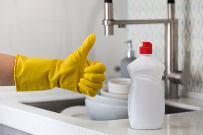 A white bottle with dishwashing gel and a hand 