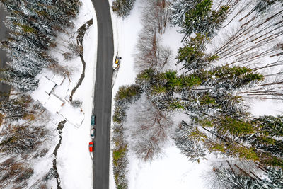 Aerial view of cars on snowcovered winding road in winter forest