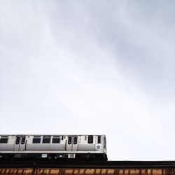 Low angle view of cropped train against sky