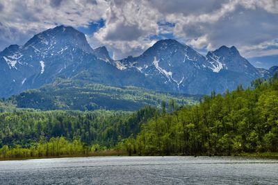 Scenic view of lake and mountains against cloudy sky