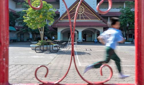 People riding bicycle on street against building